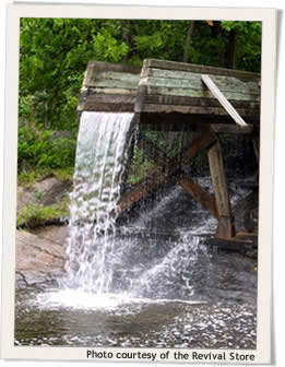 A wooden structure with water flowing over the top creating a waterfall