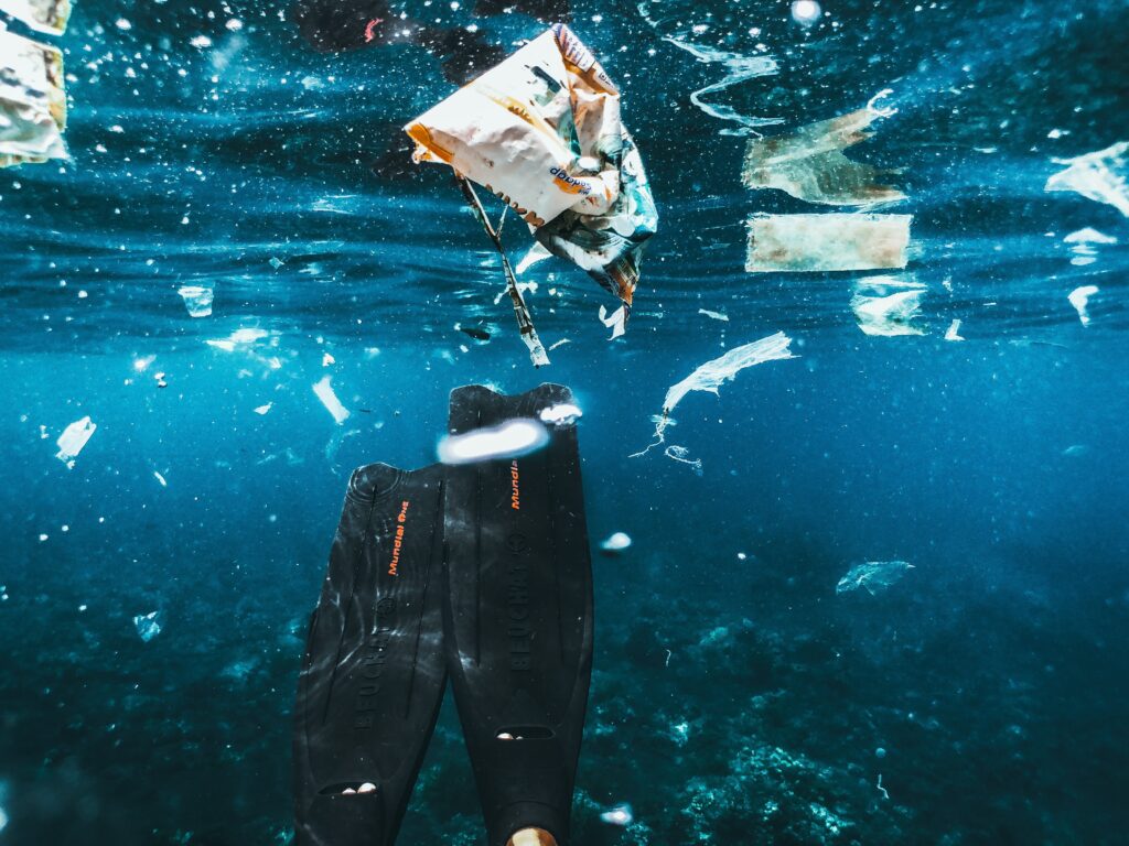 Plastic in open water with a divers flippers shown