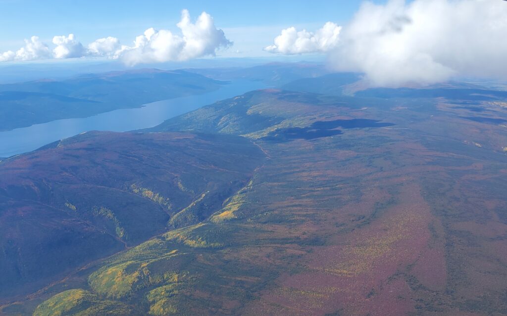 Aerial view of a landscape with rolling hills, a valley, and a river.