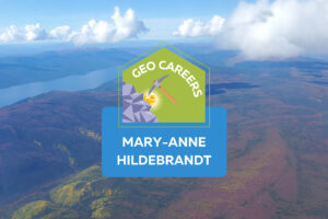 Aerial view of a landscape with rolling hills, a valley, and a river. On top of the photo text reads: "Geo Careers. Mary-Anne Hildebrandt." with the icon of a pickaxe hitting a rock.